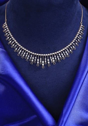 Portfolio Close-up of a sparkling diamond necklace on a blue velvet mannequin.