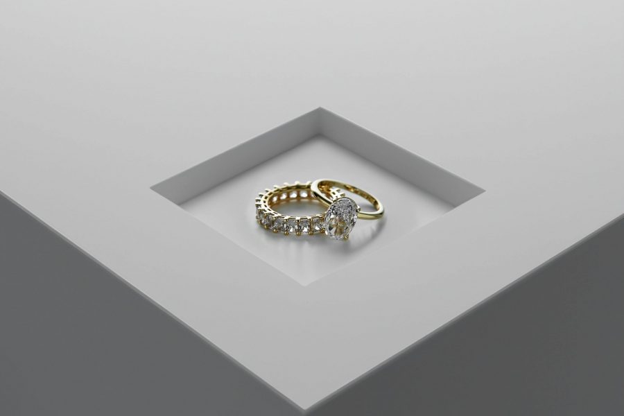 Portfolio A close-up of exquisite gold and diamond rings set on a minimalist surface.