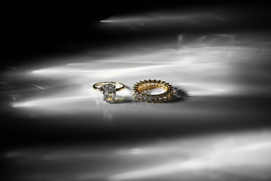 Portfolio A stunning close-up of elegant gold and diamond rings on a reflective surface.