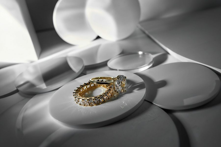 Portfolio Close-up of elegant gold and diamond rings on a modern abstract surface, showcasing luxury style.